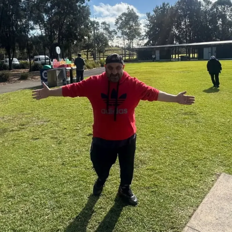 A participant with his arms stretched out, enjoying a sunny day at the park