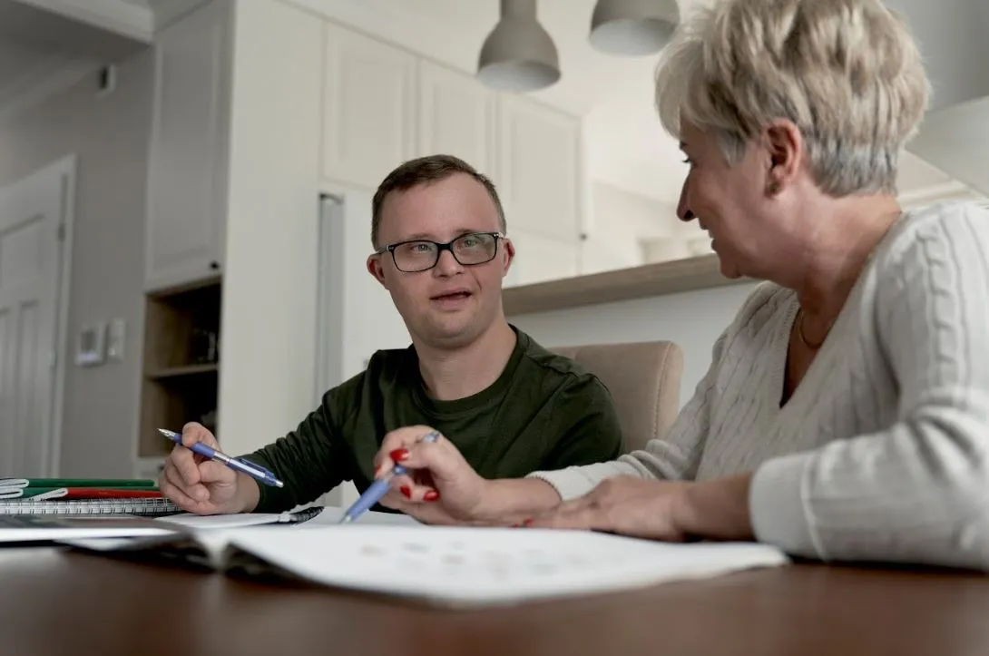 Support coordinator explaining an NDIS plan to a participant